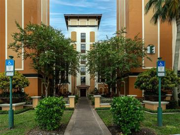 Inviting building entrance with manicured landscaping and accessible parking at 12527 Floridays Resort Dr # 401E, Orlando, FL 32821