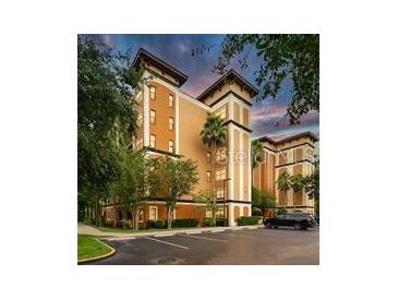 Beautiful exterior shot of a condo building featuring manicured landscaping and a parking lot at 12527 Floridays Resort Dr # 401E, Orlando, FL 32821
