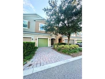 Charming townhouse with a well-manicured front yard and brick-paved driveway at 1828 Lemon Drop Ct, Apopka, FL 32712