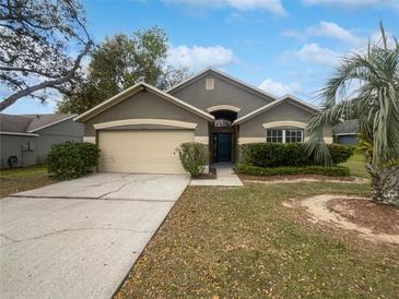 Charming single-story home featuring a well-maintained lawn, mature trees, and an attached two-car garage at 332 Lake Doe Blvd, Apopka, FL 32703