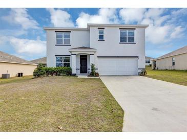 Charming two-story home with a well-manicured lawn, attached garage, and inviting entrance at 39 Hickory Course Way, Ocala, FL 34472