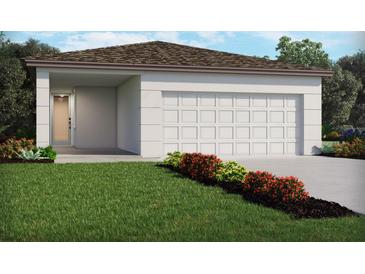 Charming single-story home featuring a two-car garage and a well-manicured front yard with colorful flower beds at 4969 Kaia Ave, Winter Haven, FL 33884