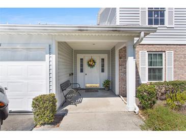 Inviting front entrance with a charming floral wreath, bench, and covered porch at 5273 Tunbridge Wells Ln # 1601, Orlando, FL 32812