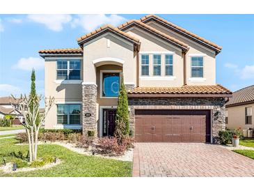 Stunning two-story home featuring a terra cotta roof, stone accents and a brick paver driveway at 612 Via Isabelle Dr, Debary, FL 32713