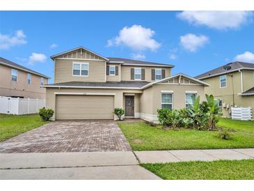 Two-story home featuring a brick driveway, a two-car garage and manicured landscaping at 638 Ogelthorpe Dr, Davenport, FL 33897