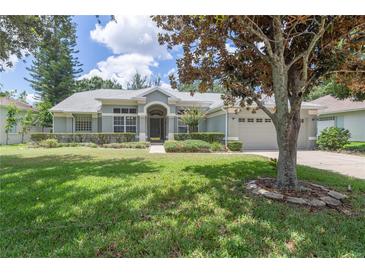Charming one-story home featuring a well-manicured lawn, mature landscaping, and a welcoming entrance at 7506 Lindenhurst Dr, Orlando, FL 32836