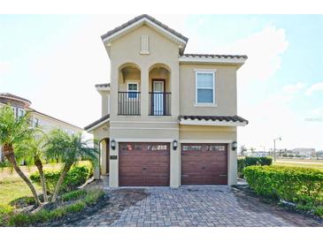 Inviting two-story home featuring a brick-paved driveway and a two-car garage, complemented by well-maintained landscaping at 7824 Loxahatchee Ct, Reunion, FL 34747