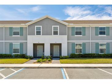 Charming two-story townhomes with gray siding and blue shutters offering a welcoming curb appeal at 926 Paradise Dr, Davenport, FL 33897