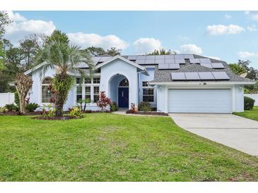Charming home exterior boasts solar panels, lush landscaping, and a well-manicured lawn at 1232 Scandia Ter, Oviedo, FL 32765