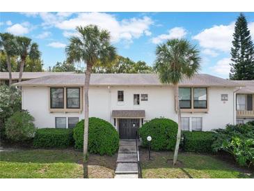 Condo building featuring palm trees, manicured shrubs, and well-maintained landscaping at 200 Maitland Ave # 86, Altamonte Springs, FL 32701