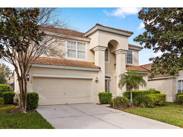 Beautiful two-story home displaying lush landscaping, a barrel tile roof, and an attached two-car garage at 2508 Archfeld Blvd, Kissimmee, FL 34747