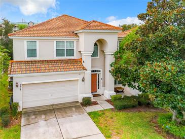 Stunning two-story home featuring a red tile roof, well-manicured lawn, and a two car garage at 2548 Archfeld Blvd, Kissimmee, FL 34747