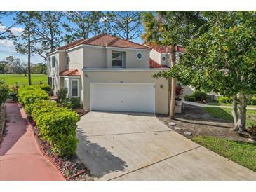 Two-story home showcasing a red tile roof, an attached two-car garage, and mature landscaping at 2630 Albion Ave, Orlando, FL 32833