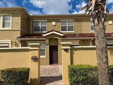 Charming townhouse with a brick-paved driveway, inviting entrance, and well-maintained landscaping at 2822 Bella Vista Dr, Davenport, FL 33897