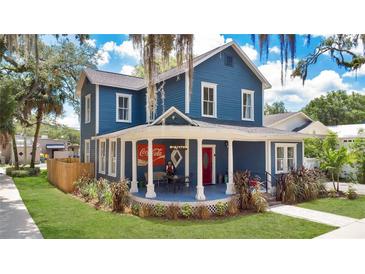 Charming two-story home with a blue facade, inviting front porch, and manicured lawn at 301 S Palmetto Ave, Sanford, FL 32771