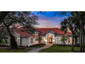 Stunning single-story home featuring a red tile roof, manicured landscaping, and a welcoming arched entryway at 3156 Winding Pine Trl, Longwood, FL 32779