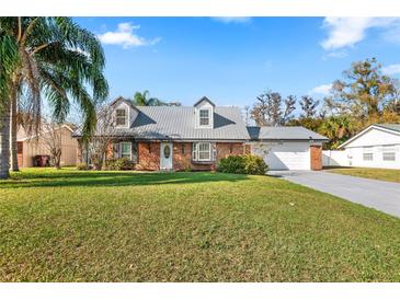 Charming brick home featuring a well-manicured lawn and a metal roof at 4306 Pine Lake Dr, St Cloud, FL 34769