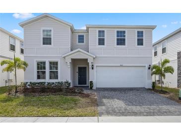 Charming two-story home featuring a paved driveway and an attached two-car garage at 4353 Lana Ave, Davenport, FL 33897
