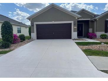 Traditional home with a two-car garage, concrete driveway and manicured front lawn at 6832 Sw 93Rd Ave, Ocala, FL 34481