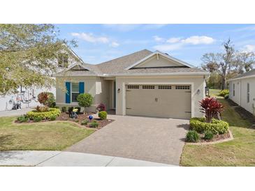 Charming home featuring a well-manicured lawn, paver driveway, and two-car garage at 7977 Hanson Bay Pl, Kissimmee, FL 34747