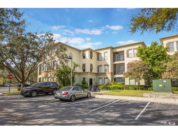 Multi-story condo building with reserved parking and lush landscaping, providing a welcoming curb appeal at 11564 Mizzon Dr # 305, Windermere, FL 34786