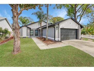 Charming single-story home with gray stucco exterior, landscaped yard and attached garage at 1296 Bridlebrook Dr, Casselberry, FL 32707