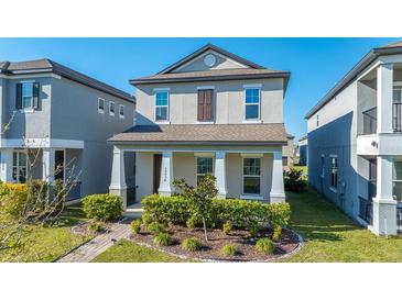 Charming two-story home features a well-maintained lawn and inviting front porch with classic architectural design at 15036 Willow Arbor Cir, Orlando, FL 32824