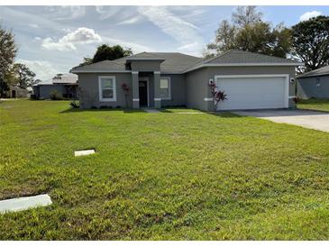 Well-maintained home with a lush green lawn and a two-car garage at 1958 Sawfish Dr, Kissimmee, FL 34759