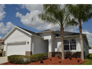 Charming single-story home featuring a two-car garage and well-maintained landscaping with palm trees at 2657 Youngford St, Orlando, FL 32824