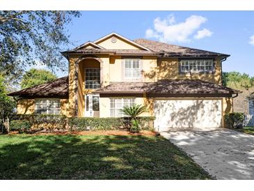 Charming two-story home featuring a well-manicured lawn and an attached two-car garage at 729 Strihal Loop, Oakland, FL 34787