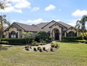 Charming, single-story stucco home with manicured landscaping and a beautiful brick-paved walkway leading to the front door at 12860 Jacob Grace Ct, Windermere, FL 34786