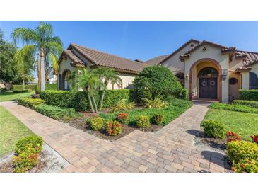 Charming single-story home featuring lush landscaping and a brick walkway leading to the front door at 12860 Jacob Grace Ct, Windermere, FL 34786