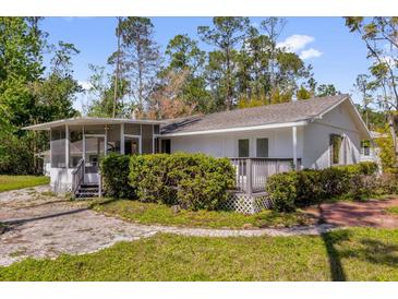 Charming single-story home with screened porch, patio, and lush landscaping at 13128 Devonshire Rd, Orlando, FL 32832