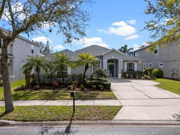 Charming single-story home featuring a well-manicured lawn and inviting curb appeal with palm trees at 15144 Spinnaker Cove Ln, Winter Garden, FL 34787