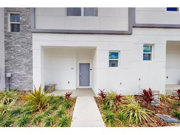 Contemporary townhome exterior with gray accents, manicured landscaping, and a welcoming entrance at 257 Famagusta Dr, Davenport, FL 33896