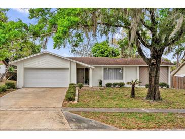 Charming single-story home with a well-maintained lawn, mature tree, and a two-car garage at 414 Sundown Trl, Casselberry, FL 32707