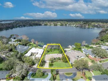 Breathtaking aerial view of a lakefront property with lush landscaping and direct access to the water at 443 Lakewood Dr, Winter Park, FL 32789