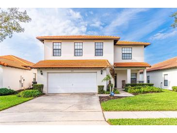 Charming two-story home with a terra cotta roof, well-manicured lawn, and a spacious two car garage at 502 Summer Place Loop, Clermont, FL 34714