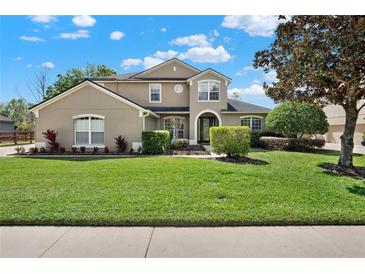 Charming two-story home boasting a well-manicured lawn and mature landscaping on a sunny day at 558 Osprey Lakes Cir, Chuluota, FL 32766