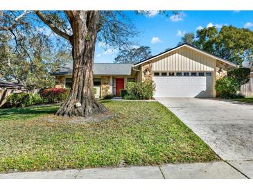 Charming single-story home boasts a stone facade, well-manicured lawn, and a two-car garage at 600 Heather Brite Cir, Apopka, FL 32712