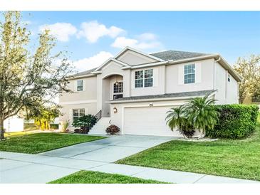 Charming two-story home featuring a well-manicured lawn and a two-car garage at 1865 Sanderling Dr, Clermont, FL 34711