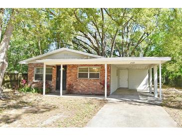 Charming brick home with a carport, beautiful landscaping, and a welcoming entrance at 2519 Poinsetta Ave, Sanford, FL 32773