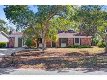 Charming single-story brick home with mature trees, offering shade and curb appeal at 5325 Glasgow Ave, Orlando, FL 32819