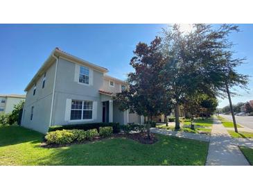 Two-story home featuring a well-maintained lawn and landscaping with inviting shuttered windows and a red tile roof at 8991 Cuban Palm Rd, Kissimmee, FL 34747