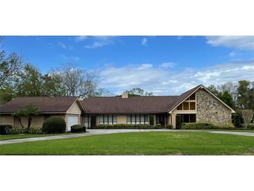Charming single-story home with manicured lawn, stone accents, and a spacious driveway at 907 Spring Valley Rd, Altamonte Springs, FL 32714