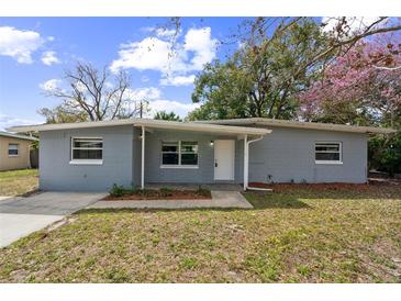 Charming single-story home with a gray brick facade, white trim, and a well-maintained front lawn at 1205 Flewelling Ave, Ocoee, FL 34761