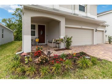 Charming front porch with comfortable seating and colorful flower garden at 1212 Bear Oak Ln, Deland, FL 32720