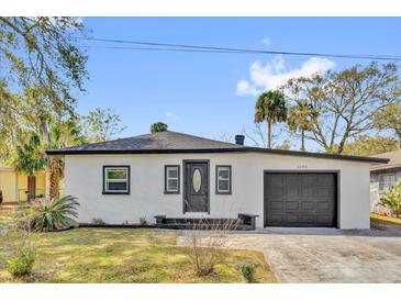 Charming single-story home with stucco exterior, dark trim, and a well-manicured front yard at 1240 Moton Ave, Sanford, FL 32771