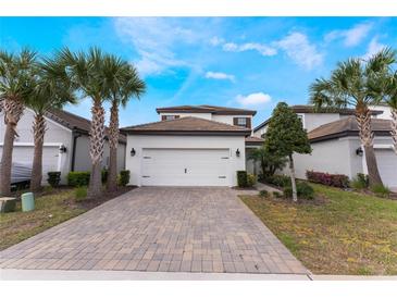 Charming two-story home with lush palm trees and a brick paved driveway offers curb appeal at 1344 Blue Stem Lane, Winter Park, FL 32792