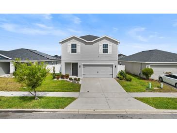 Charming two-story home with light gray siding, landscaped yard, and a two-car garage at 207 Polermo Ave, St Cloud, FL 34771